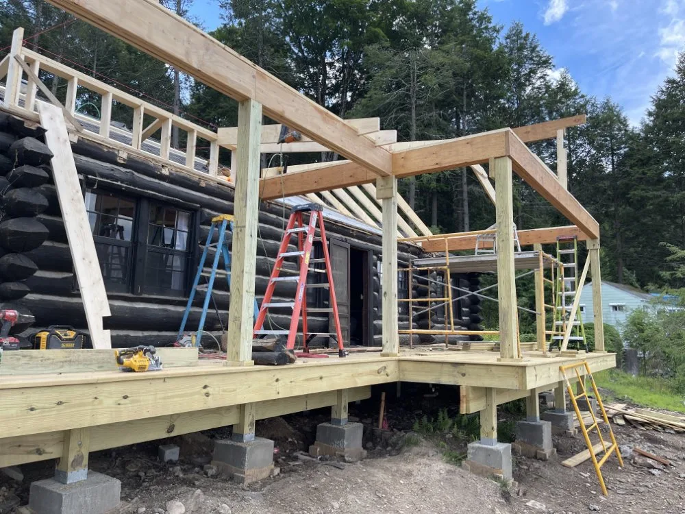 Rustic lake house addition with new roof and wall framing in progress